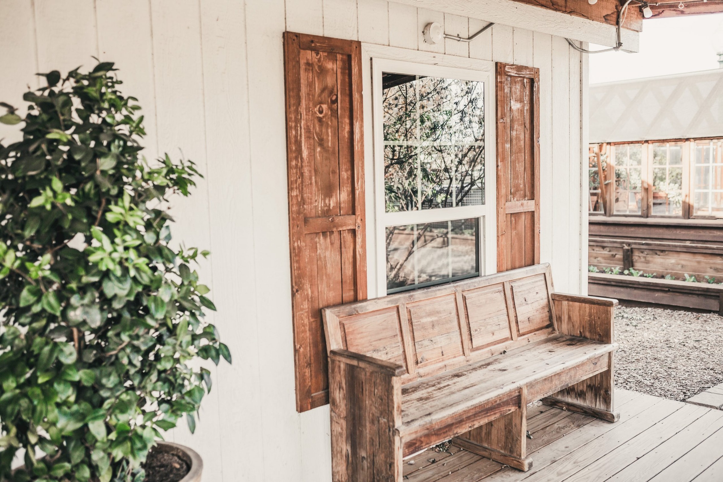 White farmhouse porch with a weathered wooden bench